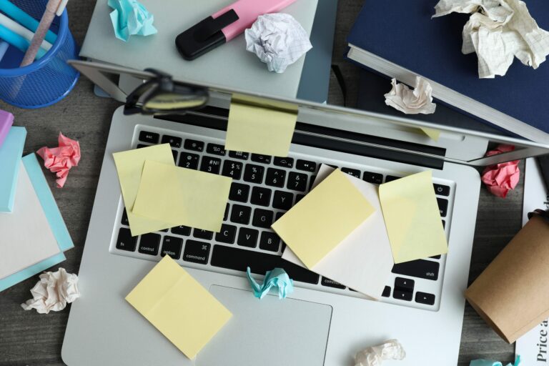 sticky notes and crumbled papers scattered on a laptop